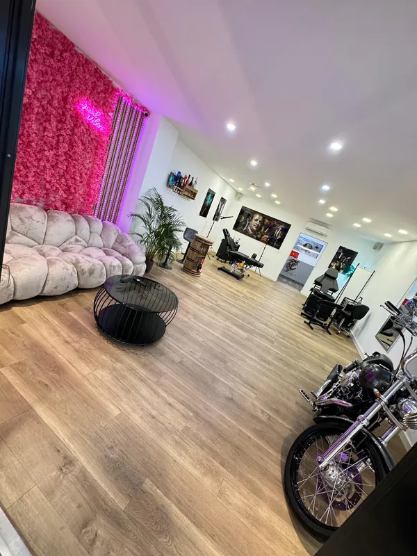 Heller Studioraum mit weißen Wänden, Holzboden, Sitzbereich und Custom-Bike