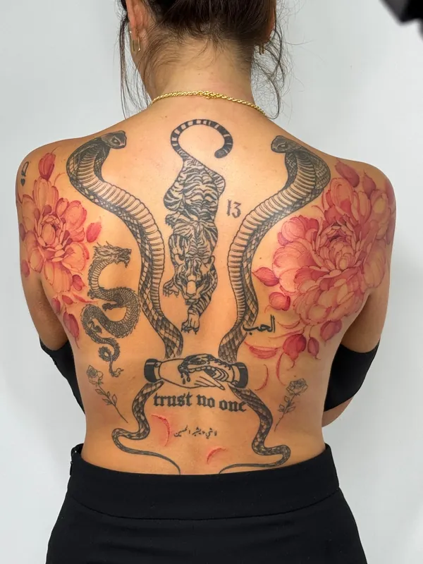 Großflächiges Rückentattoo mit Blüten und Schlangen